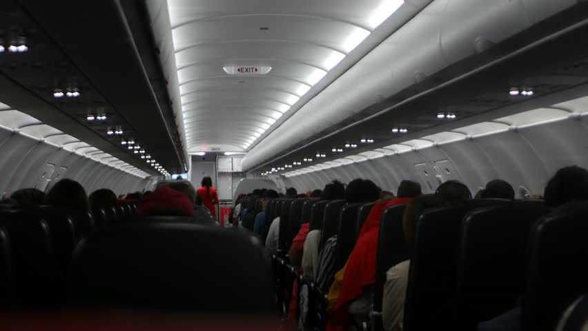 view inside airplane cabin full with passenger inside aircraft while traveling flying in night time flight while dime light down ready to landing, holiday aeroplane travel transportation