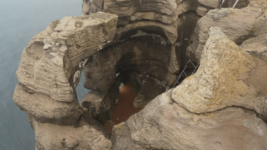 rugged rock formation of Peniche peninsula with high cliffs near Varanda de Pilatos in Portugal during dusk.