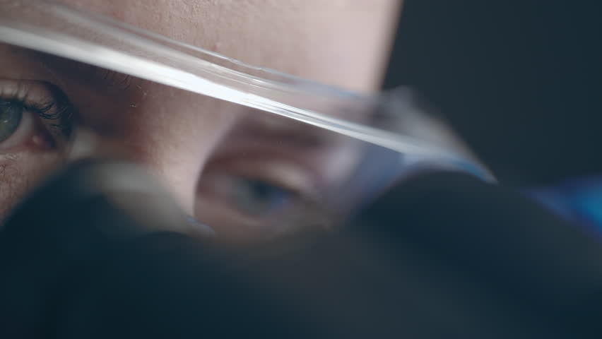 Female virologist scientist using microscope in laboratory. Biochemical and medical research. Pharmacist specialist working with lab equipment analyzing samples and searching for vaccine development