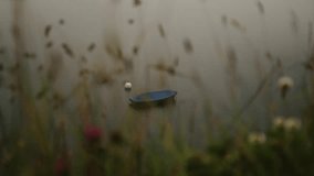 A lone blue boat drifts on a foggy alpine lake in Melchsee-Frutt, Switzerland - Powered by Shutterstock - Get 15% off with code: PIKWIZARD15