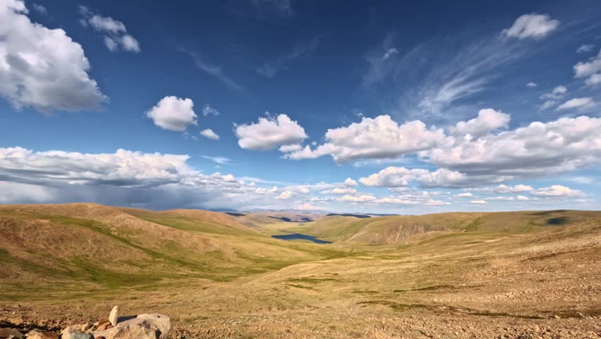 View from an off-road vehicle driving off-road in a highland area without trees. POV view from the car