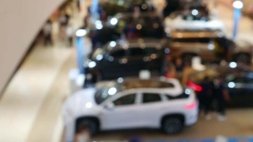 Time Lapse Blurred Car Exhibition in Shopping Mall - Defocused Auto Show Display with Bokeh Effect in Modern Showroom