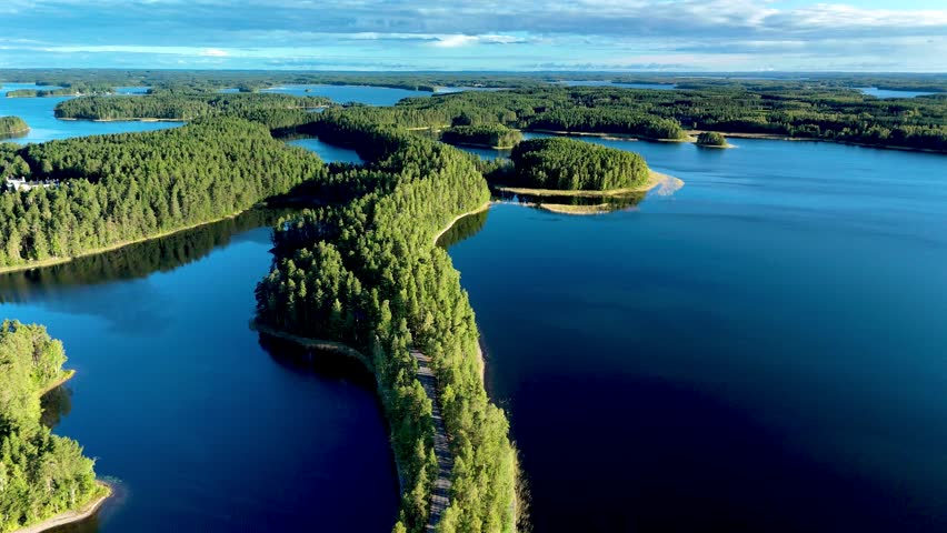 Explore the breathtaking landscape of Punkaharju, Finland, where lush green forests meet serene blue waterswith a road between. A perfect destination for nature lovers 