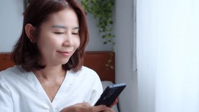 Happy Asian woman using a smartphone for internet banking, online payment, shopping, and social media. Concept for mobile technology, digital lifestyle, online transactions, and modern connectivity - Powered by Shutterstock - Get 15% off with code: PIKWIZARD15