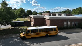 American yellow school bus in front of American school in summer. Closed during holidays. Aerial view. Traditional historic public transport for kids and students in USA. - Powered by Shutterstock - Get 15% off with code: PIKWIZARD15