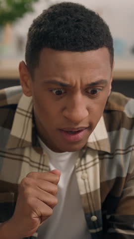 Upset sad disappointed African American male guy man failure with online betting casino lost money at home reading bad news problem trouble with mobile phone smartphone irritated unhappy app error