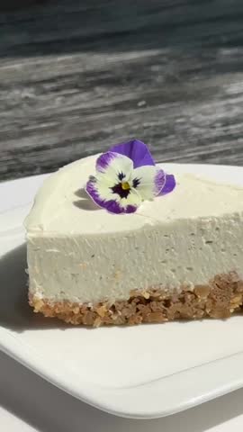 A slice of cheesecake spins on a white plate. 