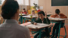 Back view unknown woman school tutor teacher asking multiracial multiethnic children four kids pupils in class lesson African American ethnic clever boy raising hand arm answering studying education - Powered by Shutterstock - Get 15% off with code: PIKWIZARD15