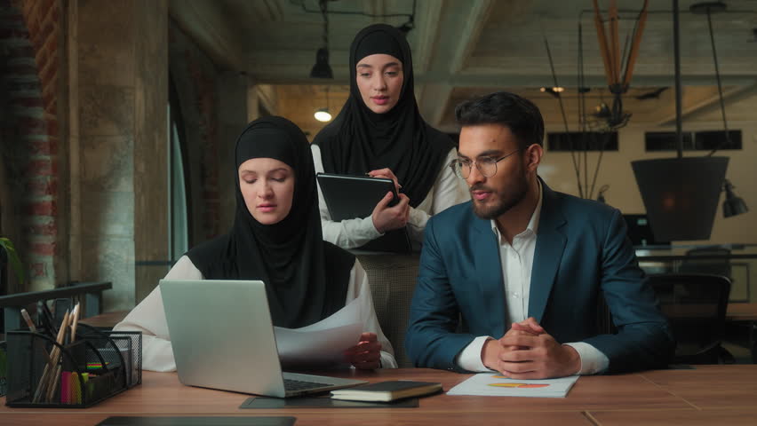 Arabian business team video call stress in office Muslim boss yelling angry mad furious businessman showing stats bad result two businesswomen laptop chat online conference virtual meeting problem - Powered by Shutterstock - Get 15% off with code: PIKWIZARD15