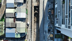 Top-down aerial view showing the contrast of a modern building and old houses divided by a subway construction trench. - Powered by Shutterstock - Get 15% off with code: PIKWIZARD15