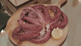 delicious octopus with lemon garnish on rustic wooden board - Powered by Shutterstock - Get 15% off with code: PIKWIZARD15