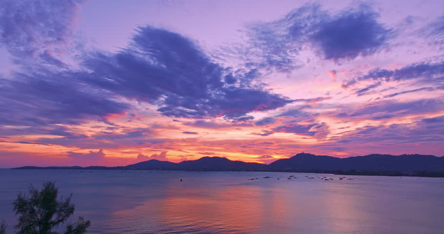 Aerial view of colorful sky in sunset above the sea. Nature video High quality footage Scene of romantic sky sunset with cloud over the mountain range background. creative nature and travel concept
