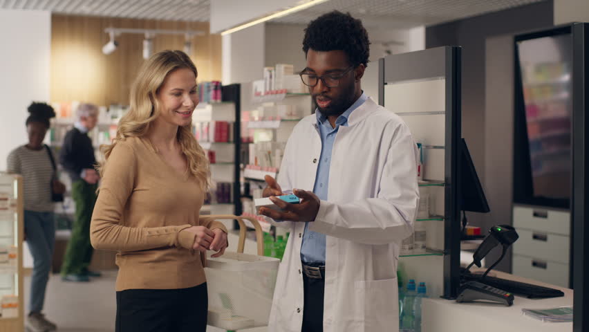 African American man pharmacist consulting customer medical prescription Caucasian woman buying medicine in pharmacy doctor patient assisting help pharmaceutical health care order pills drugs vitamins