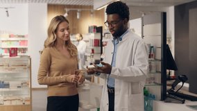 African American man pharmacist consulting customer medical prescription Caucasian woman buying medicine in pharmacy doctor patient assisting help pharmaceutical health care order pills drugs vitamins - Powered by Shutterstock - Get 15% off with code: PIKWIZARD15