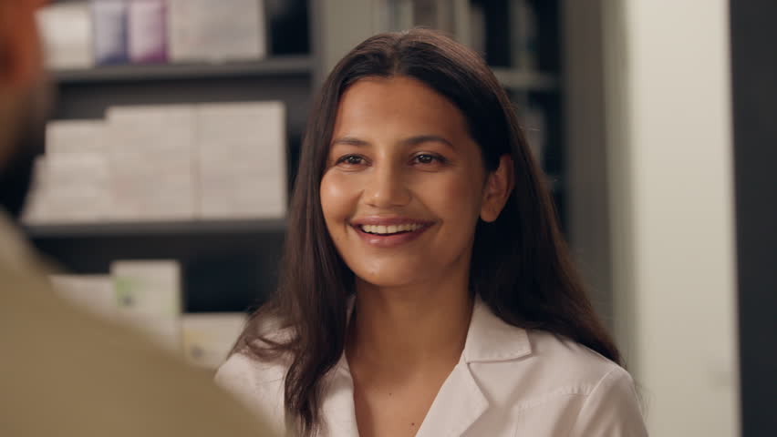 Indian woman pharmacist talking to customer in pharmacy smiling female consulting patient with prescription diagnosis medical professional advice pharmaceutical healthcare medicine buying drugstore