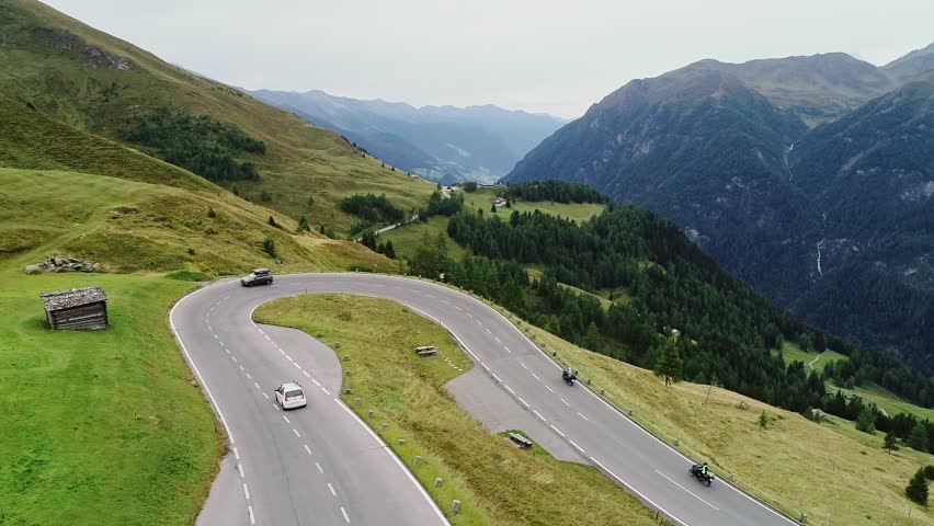 Motorcycles and cars climb steep serpentine route in Austria’s high mountains