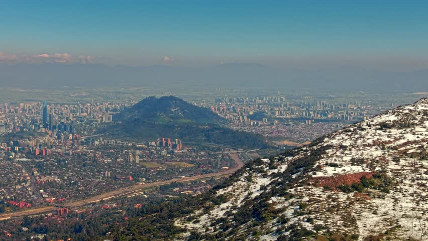Aerial cityscape of Santiago de Chile with small planes flying in Andean Snowy Mountain Cordillera Skyline