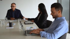 Multi generational business people working together inside modern office sharing ideas - Multiracial colleagues and entrepreneur concept - Focus on young man using laptop - Powered by Shutterstock - Get 15% off with code: PIKWIZARD15