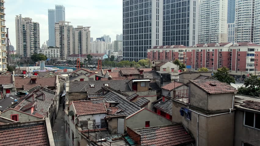 Vibrant contrast between dense Shanghai traditional neighborhoods and the sleek, towering modern skyscrapers beyond