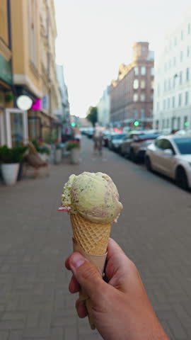 Holding a delightful Ice Cream Cone While Gently Strolling Through a Busy Urban Street Full of Life and Activity