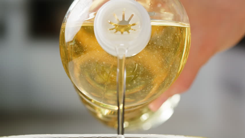 Pouring olive linen oil sunflower in different dishes close-up. Using in cooking for frying foods or as a salad dressing omega 3. Olive oil is popular supplement for meals and salads. 