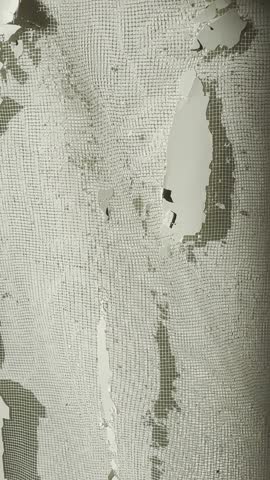 Chipped paint and exposed mesh show ongoing repair work on a wall.