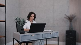 typing laptop, stylish businesswoman, career woman, Stylish businesswoman in white outfit focused on her laptop, working at modern minimalist desk in professional office setting. - Powered by Shutterstock - Get 15% off with code: PIKWIZARD15