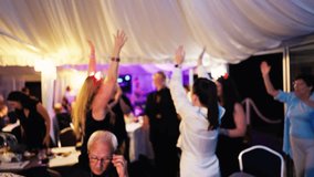 An Energetic and Joyous Celebration Under a Beautifully Illuminated Tent Filled with Dancing and Cheerful Guests - Powered by Shutterstock - Get 15% off with code: PIKWIZARD15