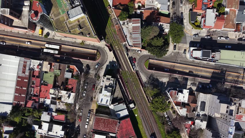 Aerial view of a passenger train passing over a railway bridge over a highway in Buenos Aires, Argentina.