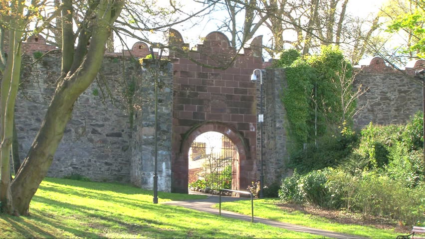 Man walking to entrance in castle walls.