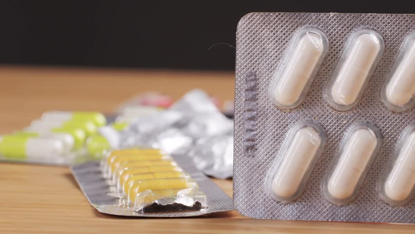 Colored medicines drugs pills, empty blisters of color pills vitamins, lot of antidepressants, on table, overdose