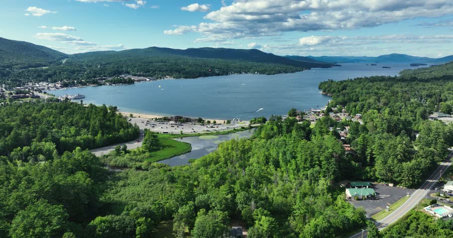 Lake George, New York, USA - July 22, 2025: Afternoon aerial summer video of the area surrounding the Lake George, NY,	Dolly forward with panning right to left movement 