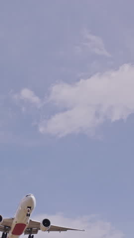 Airplane flying close overhead coming in to land in barcelona airport in vertical