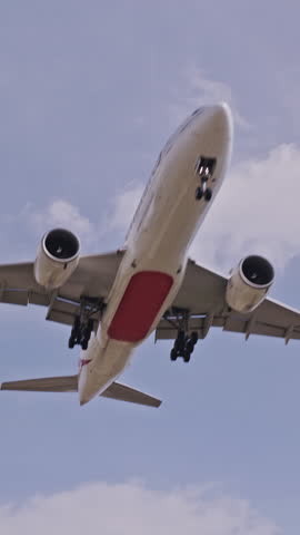 Airplane flying close overhead coming in to land in barcelona airport in vertical