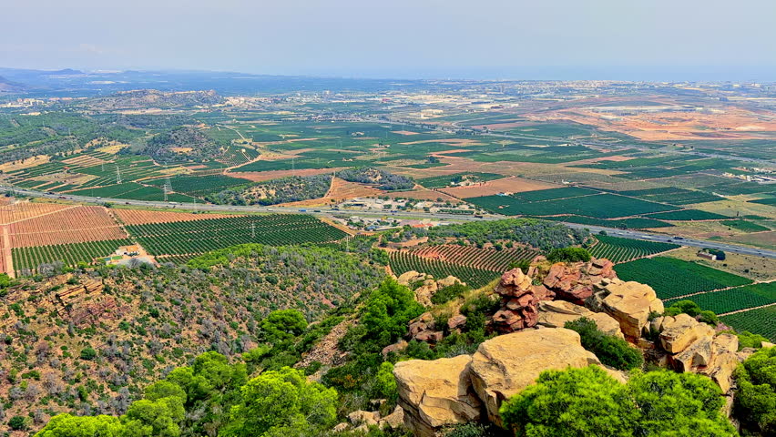 Panoramic view from above of a mountain road. Mountain road with a town view from above. Breathtaking landscape with a road in the mountains.
