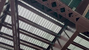 Moving under a bridge viewing the underside. Traffic moves on the road above with views of tall skyscraper buildings in the city. Located on the Chicago River in Chicago, Illinois, USA. - Powered by Shutterstock - Get 15% off with code: PIKWIZARD15