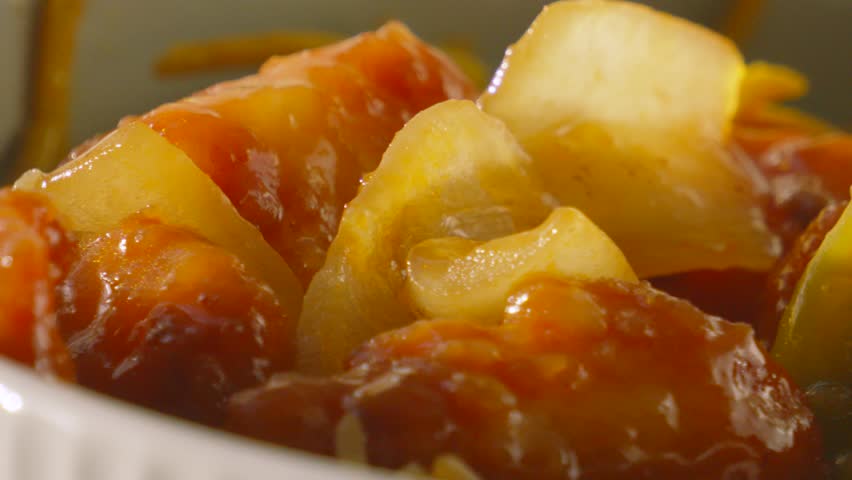 Delicious Sweet and Sour Chicken with Large Onions in Natural Sunlight as Camera Moves Slowly Across. Tasty Oriental Food.