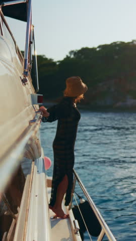 Traveling by pleasure boat on sea, happy woman admiring view from board. Happy lady standing on yacht in summer day, carefree female person feeling calmness and unity with nature, adventure trip