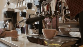 Cropped shot of female tattooed barista in uniform using coffee machine while preparing drink at coffee shop - Powered by Shutterstock - Get 15% off with code: PIKWIZARD15