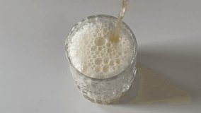 Pouring beer into a glass, foam rising and overflowing as liquid fills the cup, capturing the full dynamic process of frothing and bubbling in close-up. - Powered by Shutterstock - Get 15% off with code: PIKWIZARD15