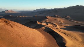 Drone footage of vast desert dunes fading into the horizon, with glowing crests and serene evening colors. - Powered by Shutterstock - Get 15% off with code: PIKWIZARD15