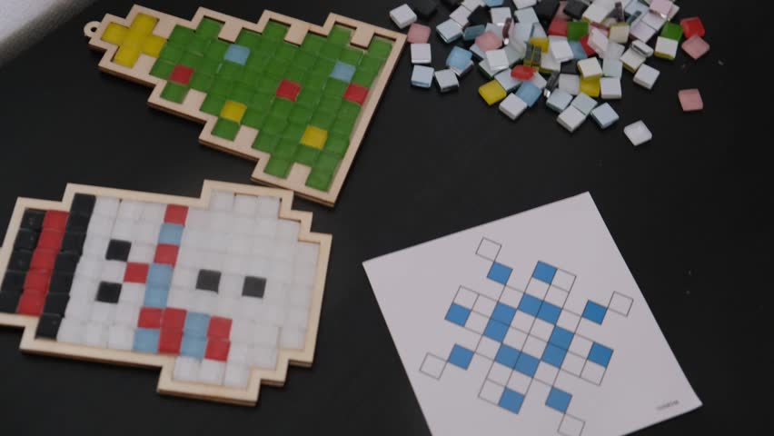 A girl makes a Christmas toy with her own hands from ceramic mosaic. Ceramic mosaic, DIY Christmas tree toy. Eco-friendly toy, educational activity for children.