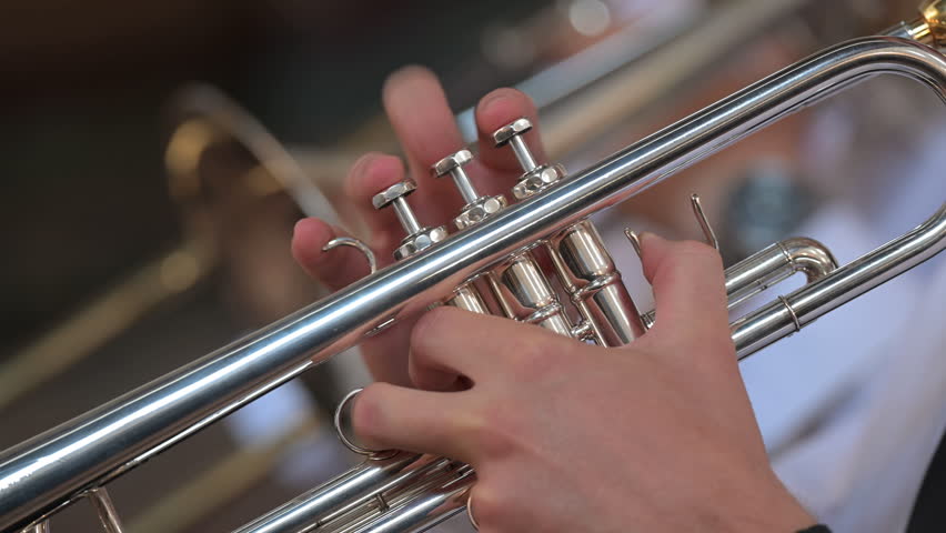 Musician playing a silver trumpet close up