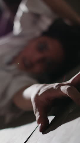 Insane woman on floor convulsing hand scratching ground turns head with crazy eyes and sinister grin staring at camera in disturbing horror closeup psychosis zombie halloween fear