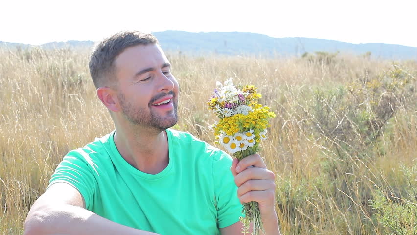 Man smelling flowers in stunning natural setting 