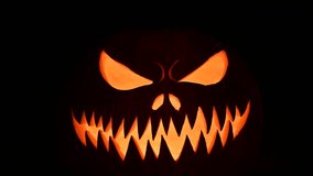 Glowing jack-o'-lantern flickers in darkness with inner light on black background. Spooky Halloween decor with eerie mood and festive pumpkin lantern effect - Powered by Shutterstock - Get 15% off with code: PIKWIZARD15