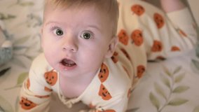Happy baby in festive sleepwear with pumpkins. Smiling infant enjoying playful moment. Great for concepts of childhood, parenting, family bonding and seasonal celebration. Adorable baby smiling. - Powered by Shutterstock - Get 15% off with code: PIKWIZARD15