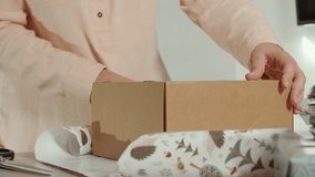 Hands positioning cardboard box on cut wrapping paper - Powered by Shutterstock - Get 15% off with code: PIKWIZARD15