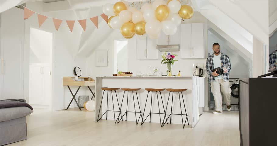 African American man placing tray on island, unfolding blanket, arranging picnic snacks, copy space. Celebration, cozy, elegance, lifestyle, domestic, casual, festive