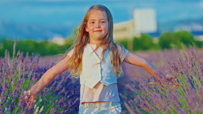 Portrait of a little beautiful girl in blooming lavender field